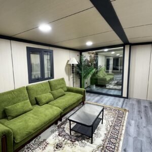 Luxury modular home lounge interior with green sofa and oversized window – MOB TIMBERCREST by Prefabia